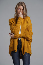 Mustard acrylic cocoon knit sleeve cardigan with textured sleeves and ribbed cuffs.