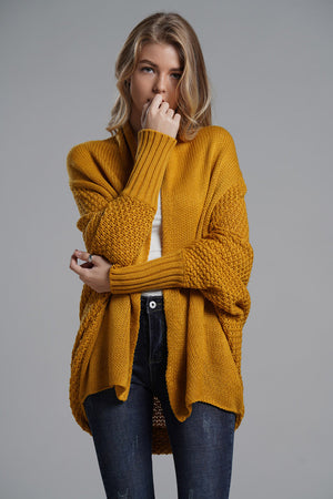 Mustard acrylic cocoon knit sleeve cardigan with textured sleeves and ribbed cuffs.