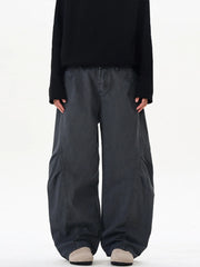Men's oversized grey cargo pants with large side pockets and a relaxed fit.
