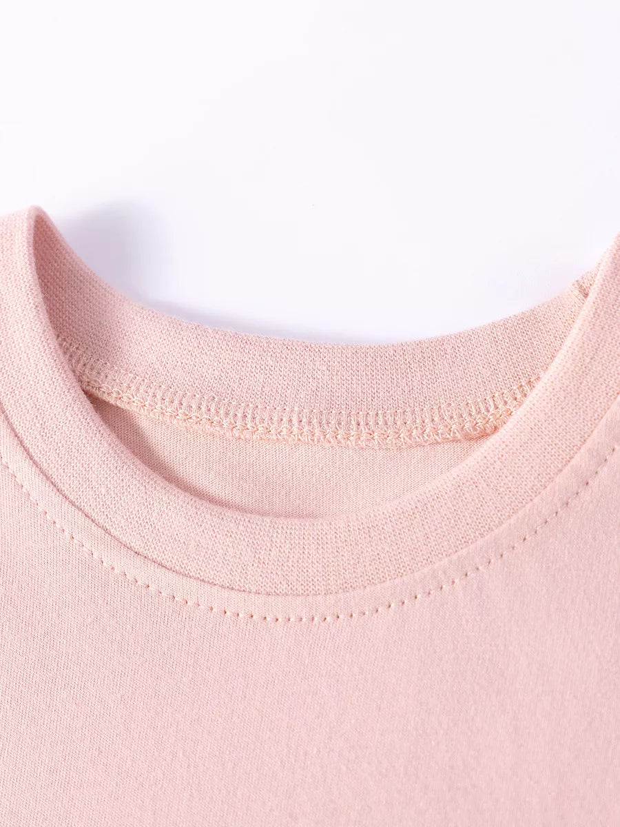 Children's pink cotton dress neckline with decorative stitching