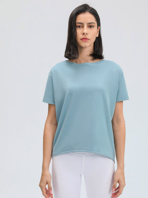 Relaxed fit performance tee in dusty blue with short sleeves and a boat neckline.