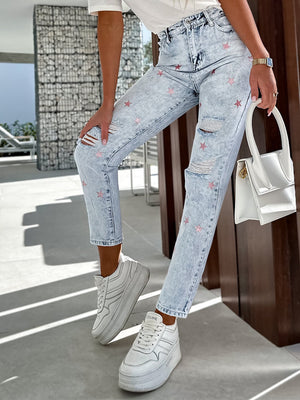 Light acid wash jeans with pink star embroidery and distressed details.