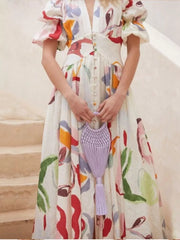 White abstract print midi dress with puff sleeves and button front.