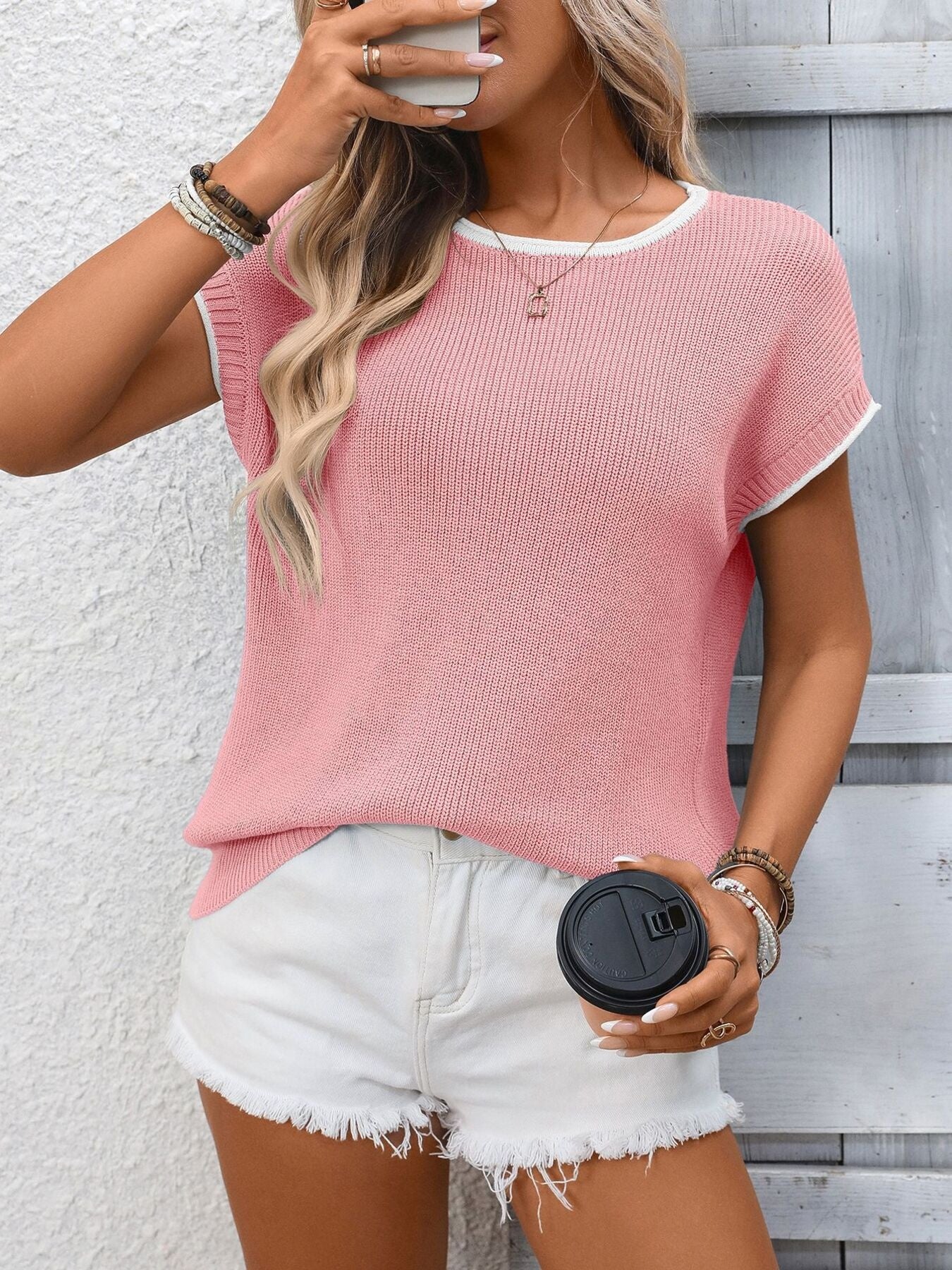 Pink ribbed knit short-sleeve top with white trim detail.