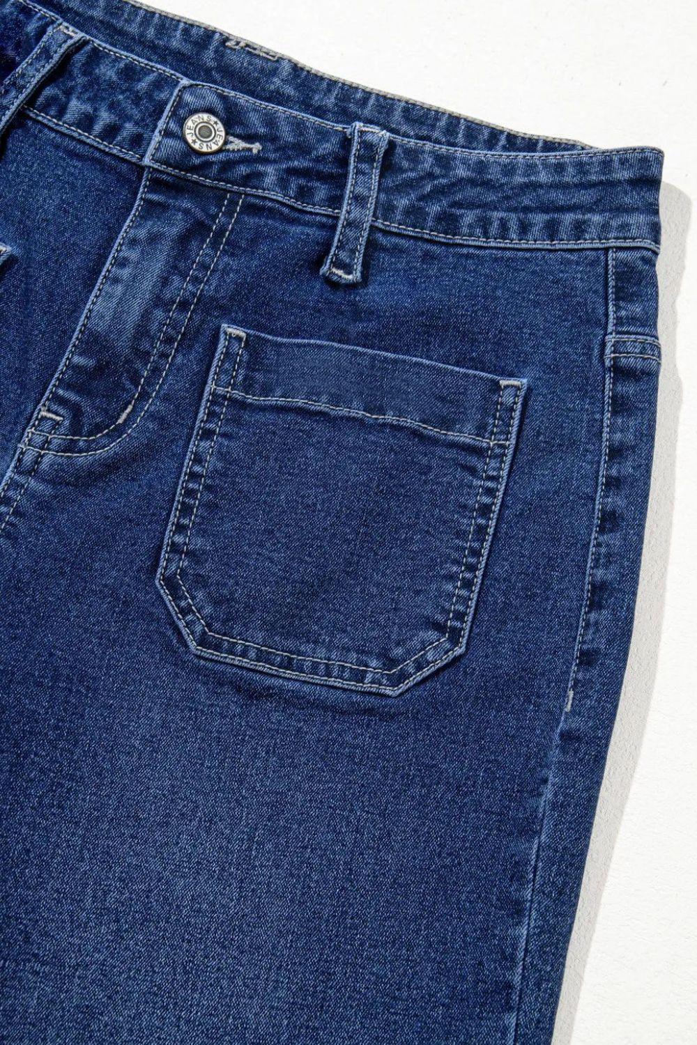 Medium wash denim jeans with utility pocket detail and button fly.
