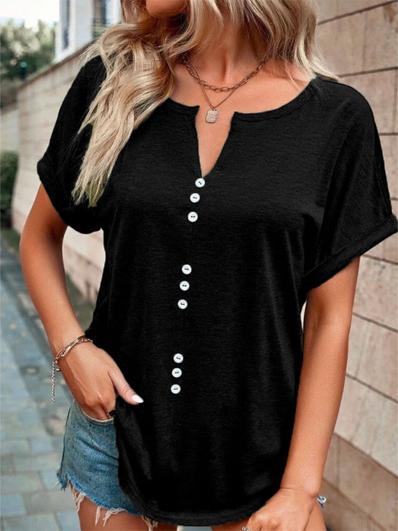 Black short sleeve t-shirt with V-neck and decorative buttons