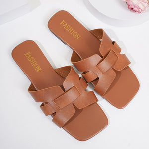 Brown woven strap slide sandals with square toe and "FASHION" detail.