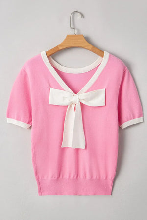 Pink knit top with contrast trim and a white bow detail on the front.