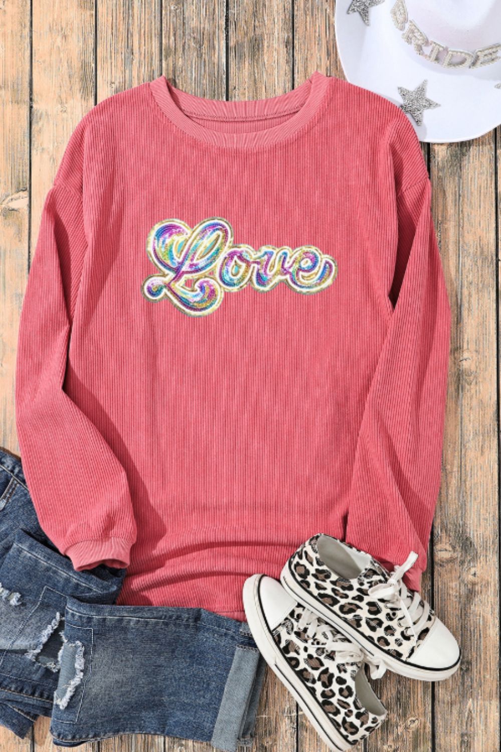 Burnt coral corduroy sweatshirt with iridescent sequin "Love" appliqué.