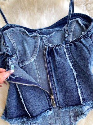 Denim cami with raw hem detail and front zipper closure.