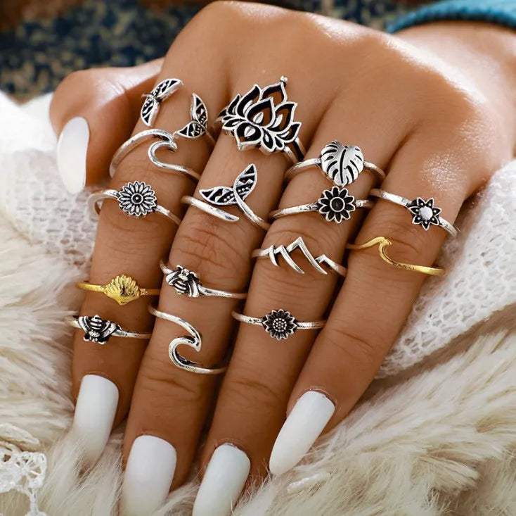 Botanical & Sculptural Ring Stack in silver alloy with lotus, flower, bee, wave, and mountain designs.