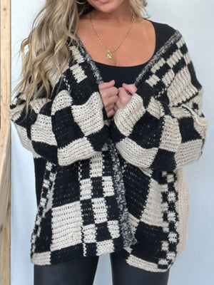 Oversized black and beige checkerboard knit cardigan with wide sleeves and open front.