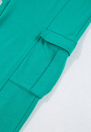 Turquoise cargo pocket loungewear pants detail with flap pocket and stitching.