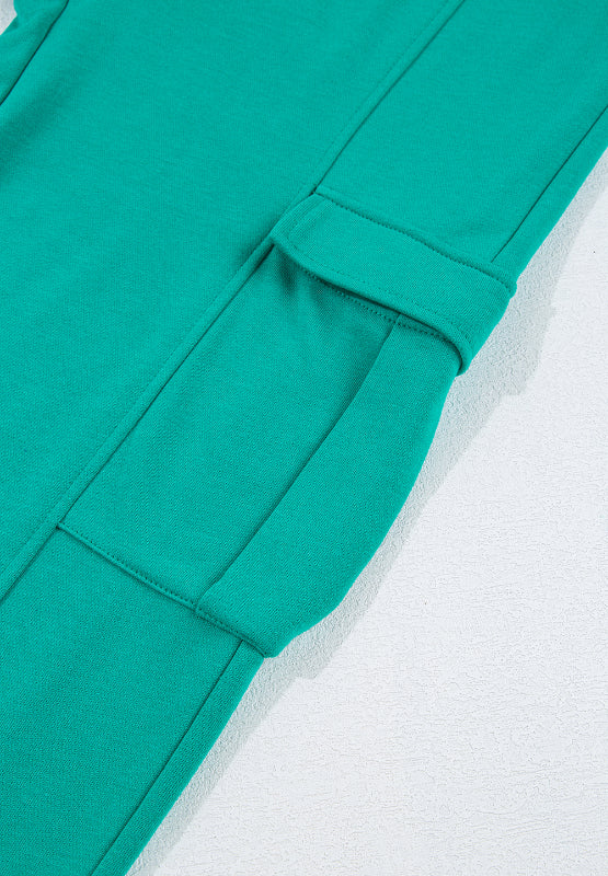 Turquoise cargo pocket loungewear pants detail with flap pocket and stitching.