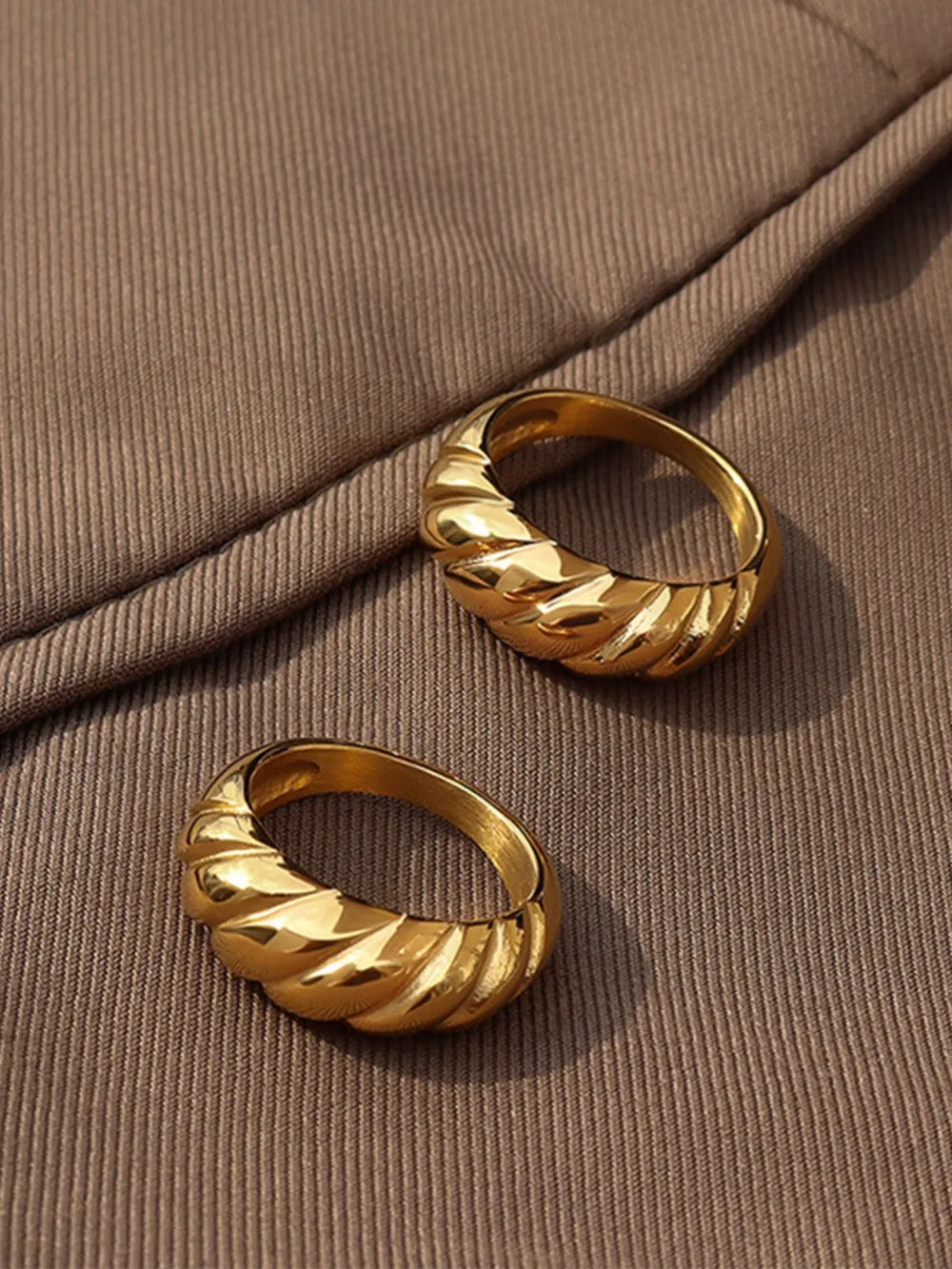 Gold sculpted steel croissant ring with twisted band detail