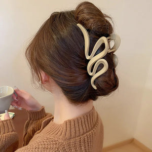 Sculptural hair claw in Dust Storm acrylic with serpentine design.