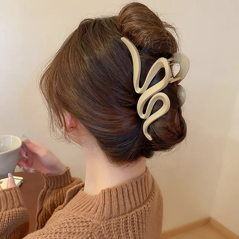Sculptural hair claw in Dust Storm acrylic with serpentine design.