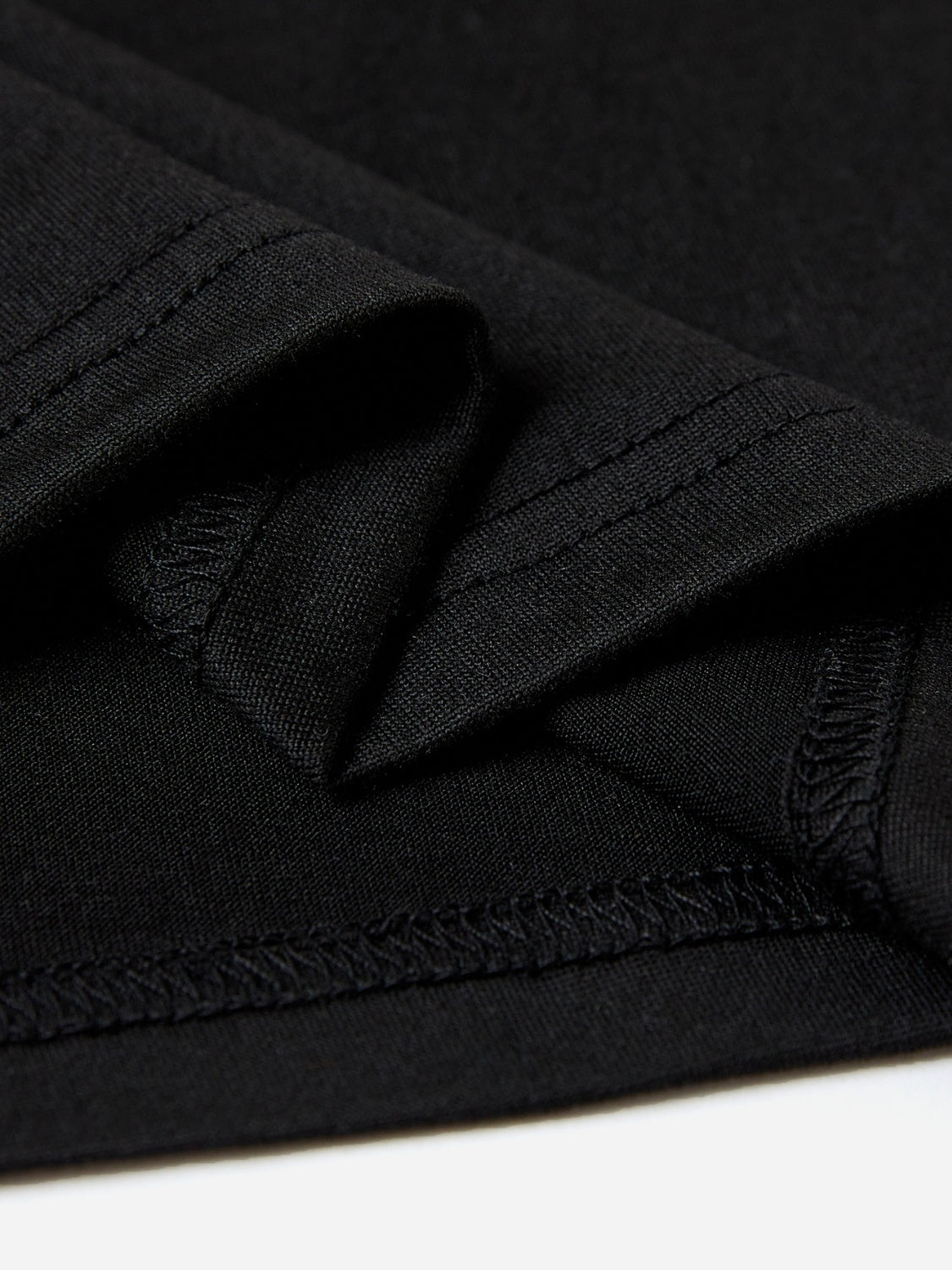 Black polyester t-shirt detail showing stitching and fabric texture.