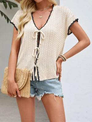 Breezy tie-front knit cardigan in apricot with contrast trim and short sleeves.