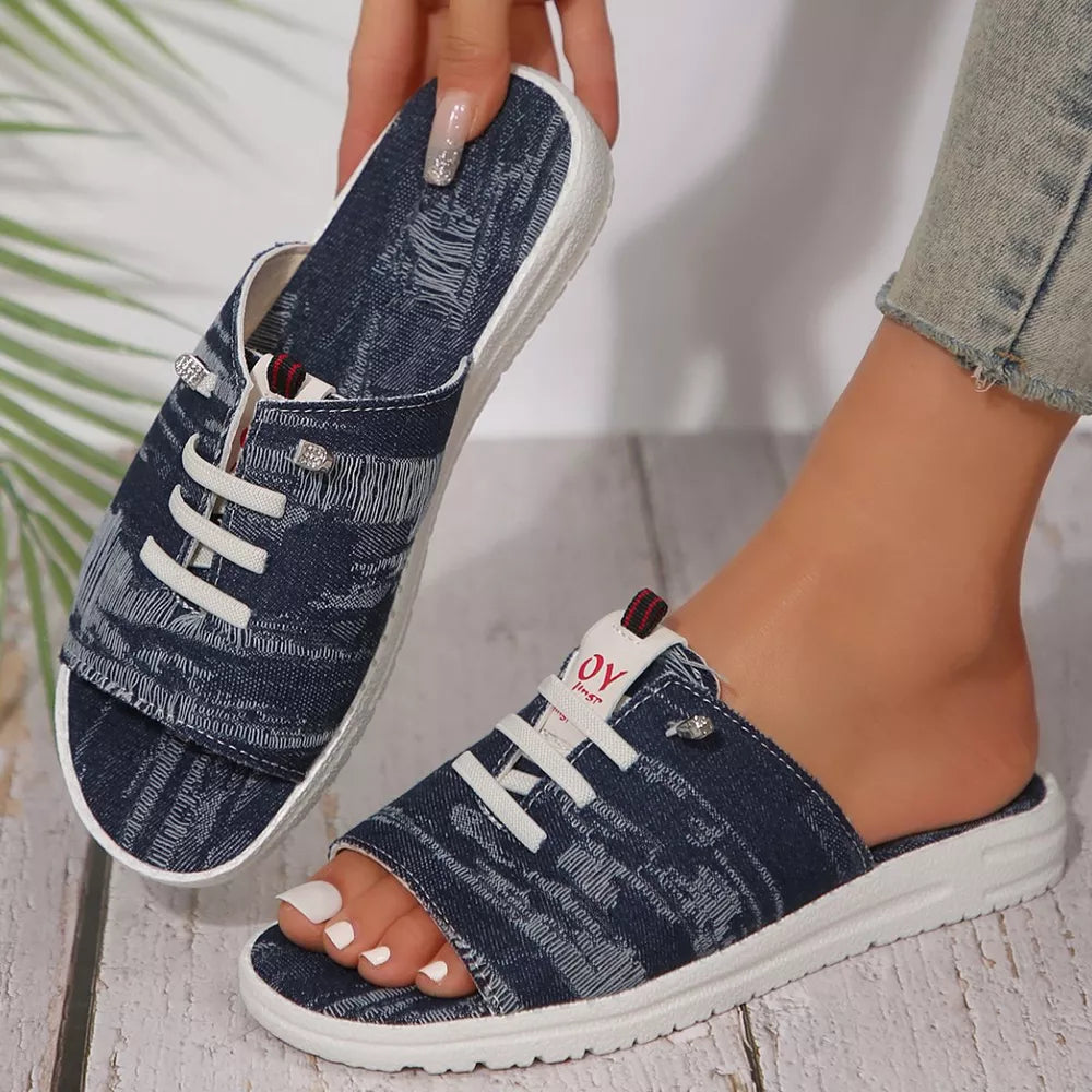 Distressed dark blue canvas open-toe platform sandals with white laces and white soles.