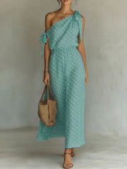 Sage polka dot one-shoulder maxi dress with cinched waist and tie details.