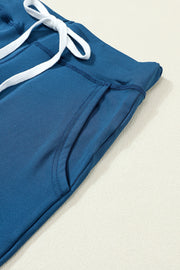 Slim-fit dark blue drawstring joggers with white tie and side pocket detail.