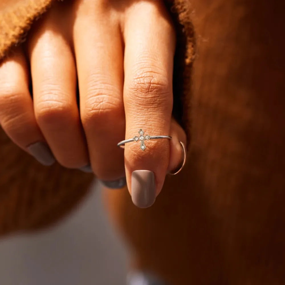 Delicate diamond cross ring in silver with sparkling stones.