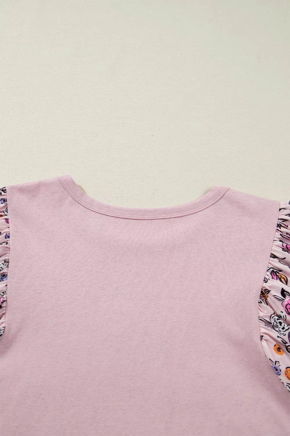 Maternity crew neck shirt in pink cotton with ruffled floral patchwork sleeves.