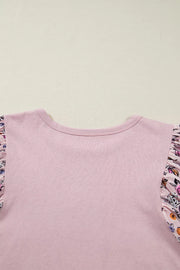 Maternity crew neck shirt in pink cotton with ruffled floral patchwork sleeves.