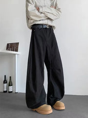 Black men's baggy sweatpants with pockets and a belted waist, styled with a striped shirt.