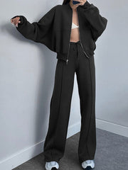 Black zip-up bomber jacket and wide-leg sweatpants with drawstring waist and front seam detail.