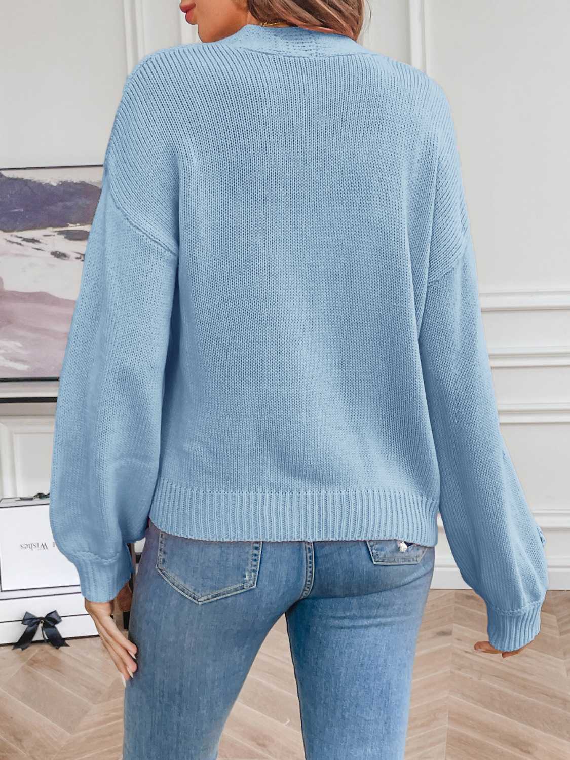 Light Blue acrylic knit cardigan with balloon sleeves and embroidered detail on the cuff.