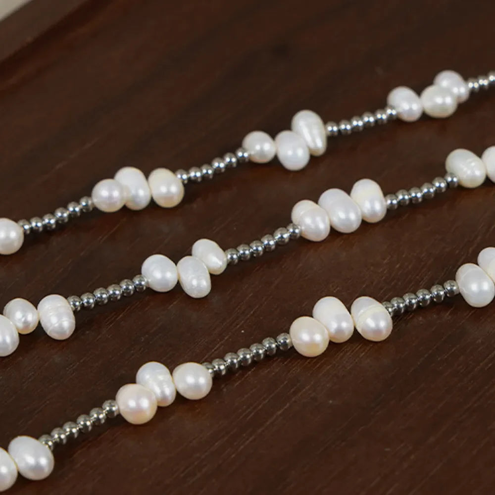 Silver necklace with irregular pearl clusters and small metallic beads.