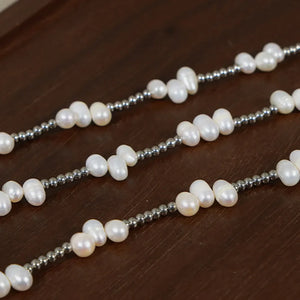 Silver necklace with irregular pearl clusters and small metallic beads.