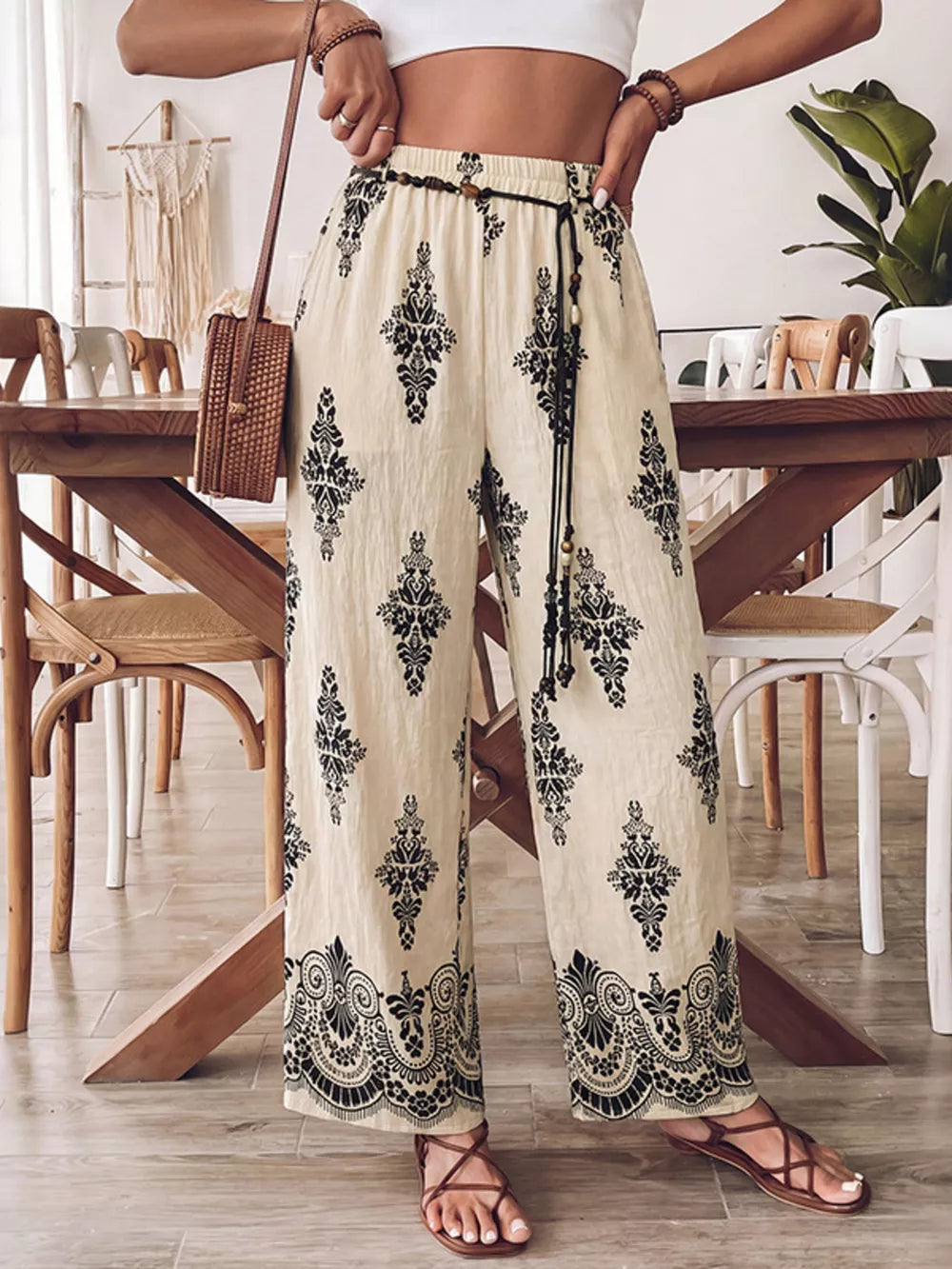 Beige wide leg maternity pants with black boho print and drawstring waist.