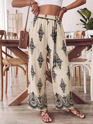 Beige wide leg maternity pants with black boho print and drawstring waist.