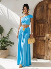 Sky blue one-shoulder ruched crop top and maxi skirt set with gold floral detail at waist.