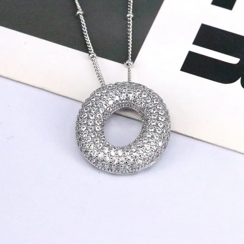Pave initial pendant necklace with beaded chain, featuring a circular pendant encrusted with clear stones.