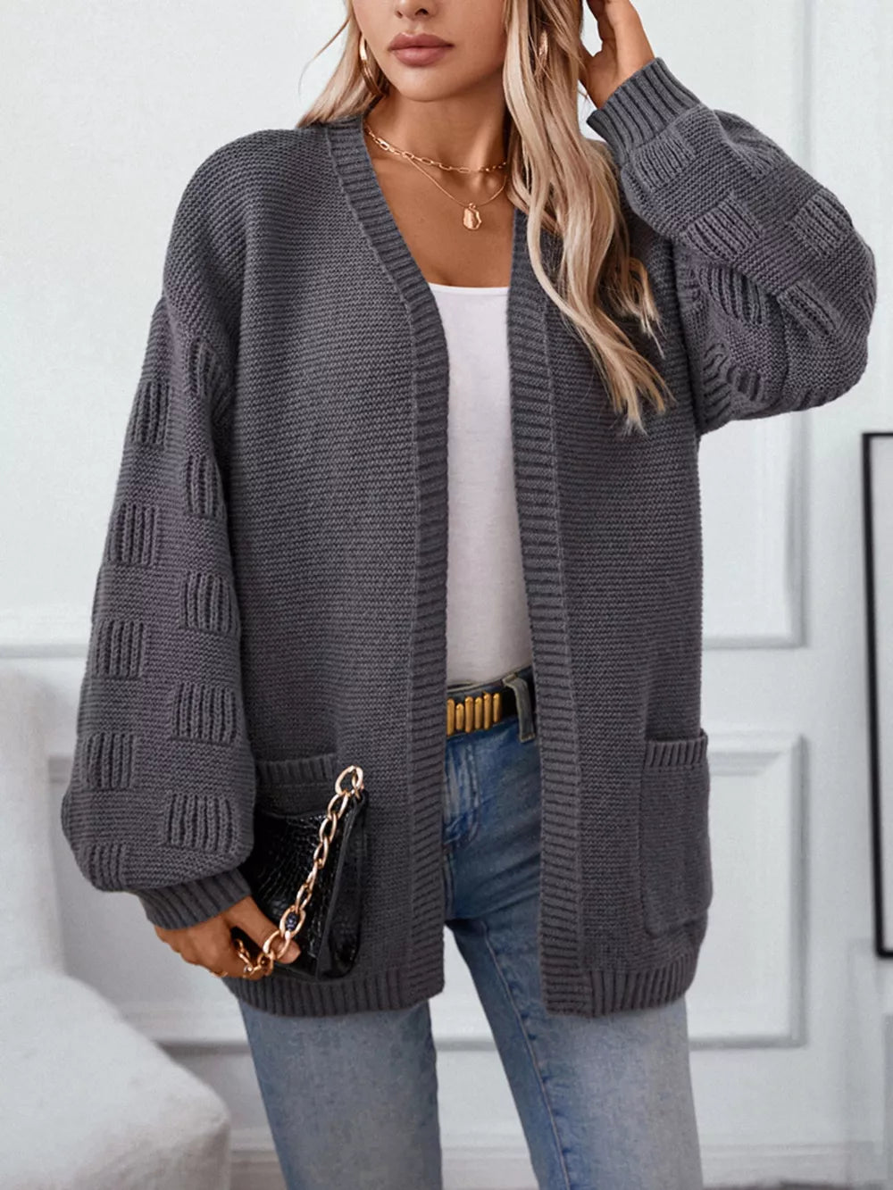 Chunky knit open-front cardigan in dark gray with pockets and textured sleeves.