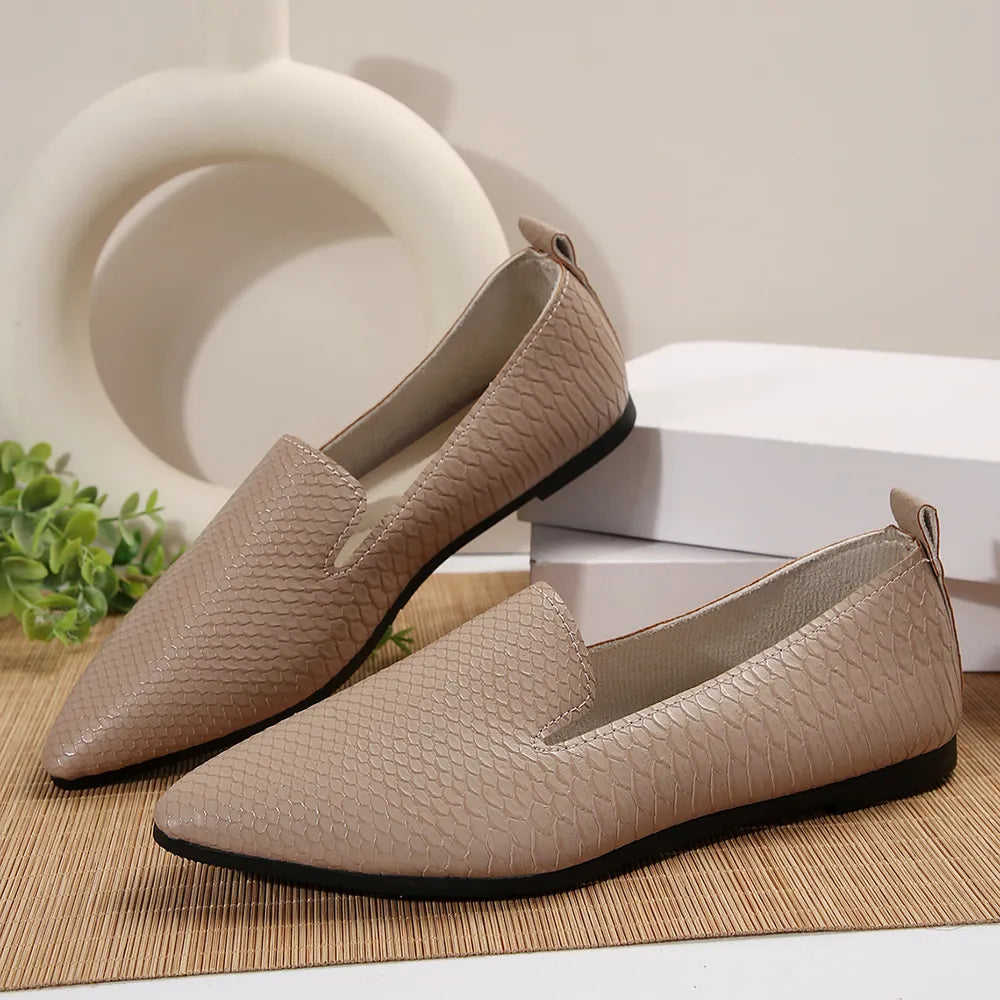 Textured pointed-toe slip-on loafers in beige with a subtle snakeskin pattern.