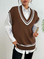 Chocolate acrylic knit vest with white contrast trim, V-neck, sleeveless, styled over a white shirt.