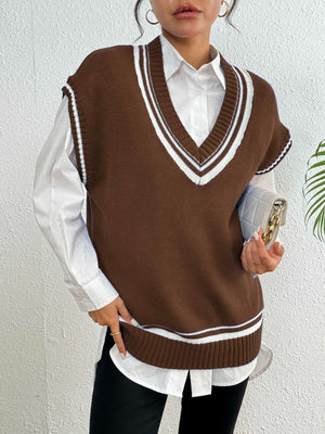 Chocolate acrylic knit vest with white contrast trim, V-neck, sleeveless, styled over a white shirt.
