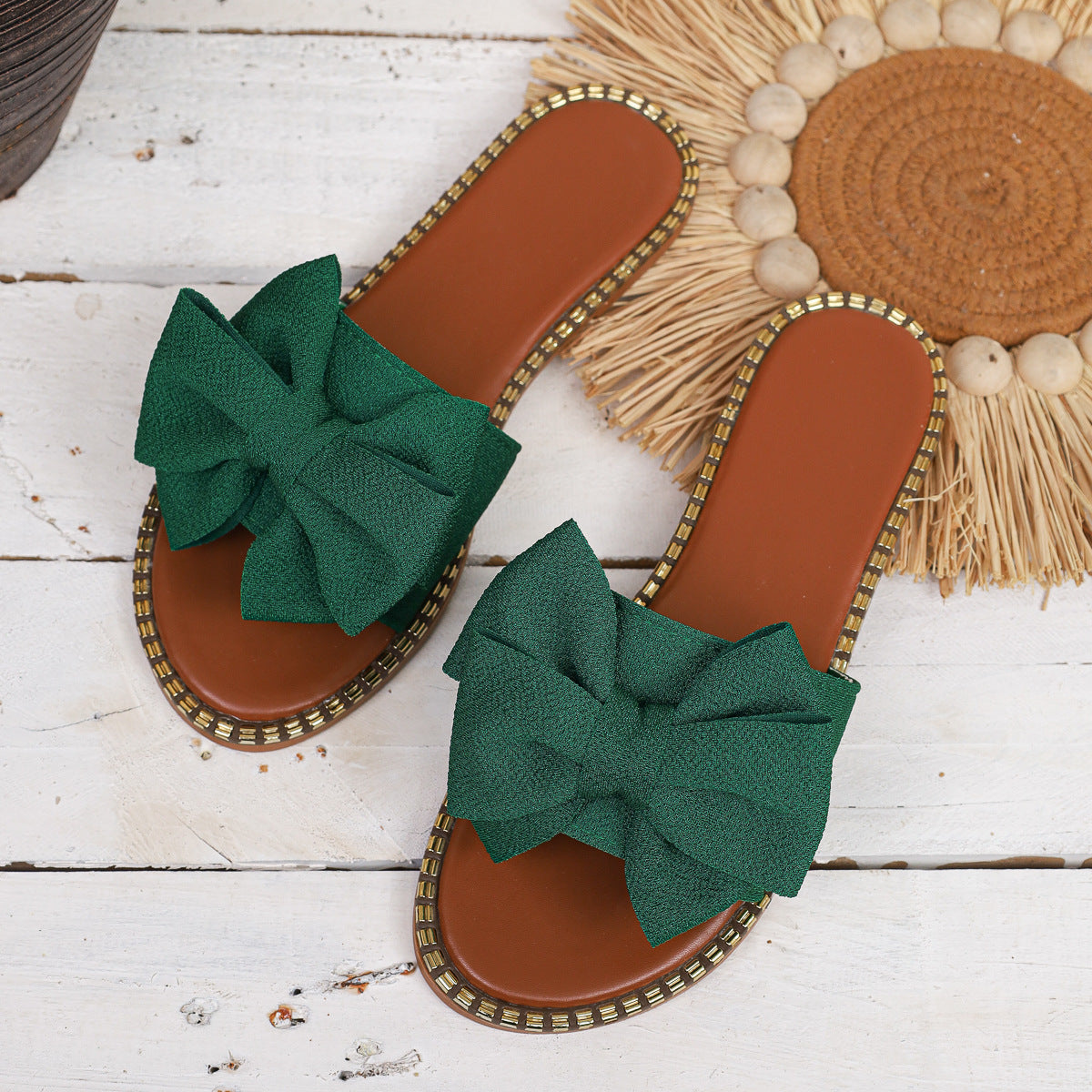 Green bowknot sandals with brown footbed and gold beaded trim.
