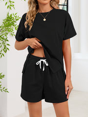 Black relaxed two-piece set with crew neck tee and drawstring shorts with pockets.