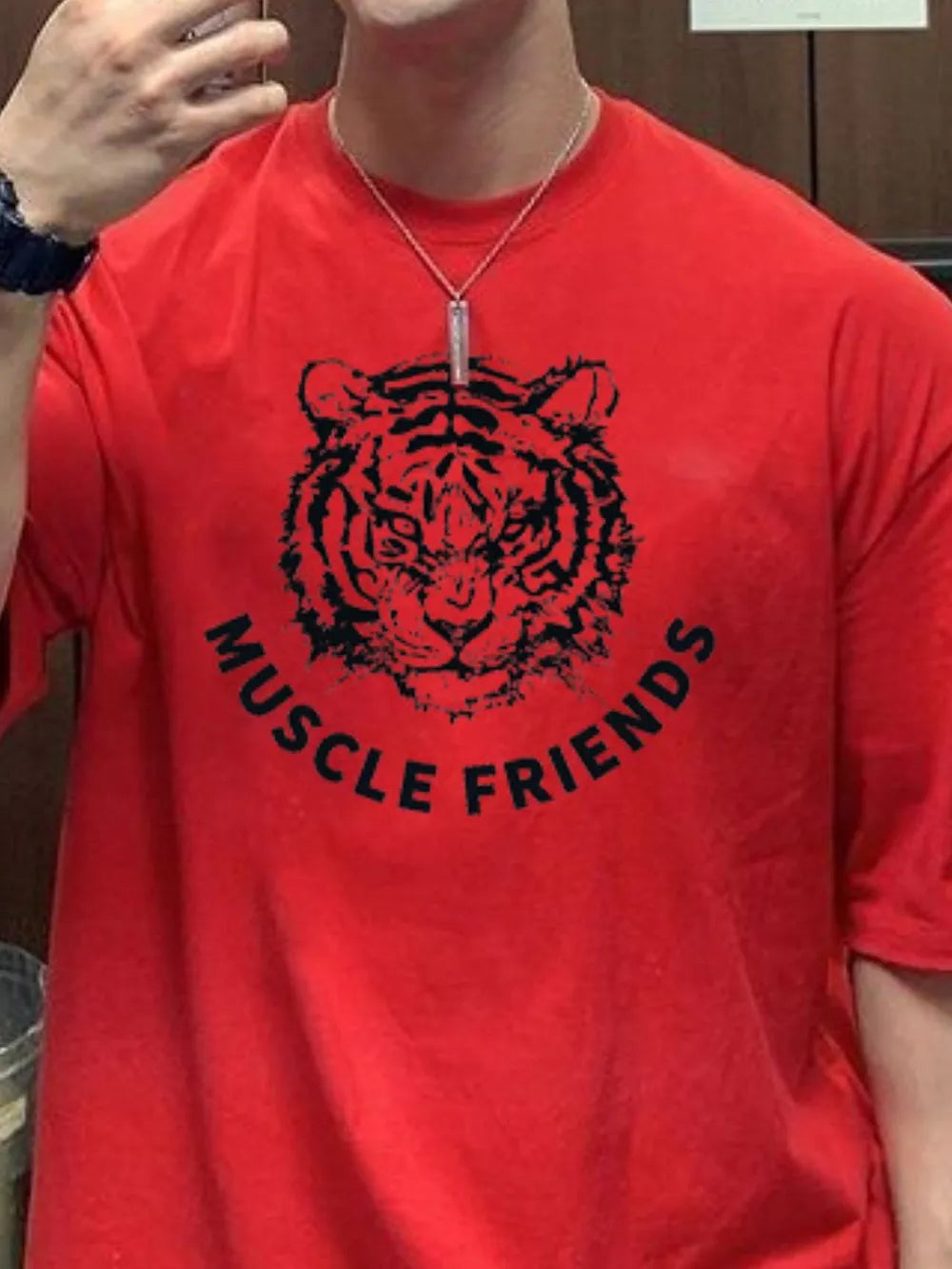 Red oversized tee with black tiger graphic and Muscle Friends text