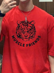 Red oversized tee with black tiger graphic and Muscle Friends text