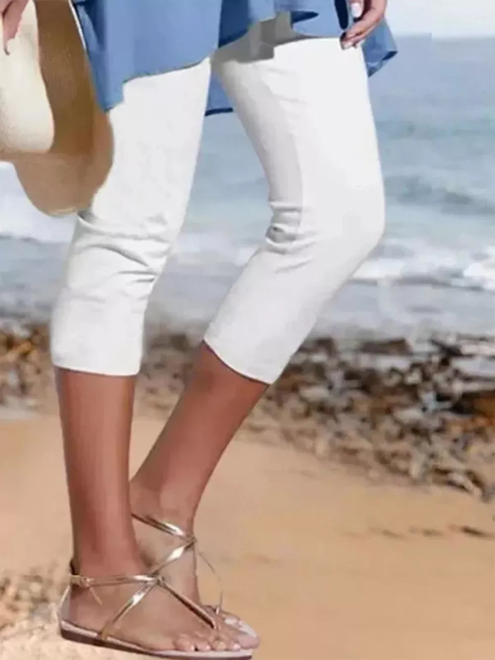 White cropped leggings with a casual fit, shown on a model at the beach.
