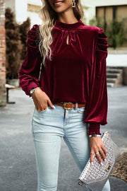 Burgundy velvet keyhole puff-sleeve blouse with smocked cuffs.