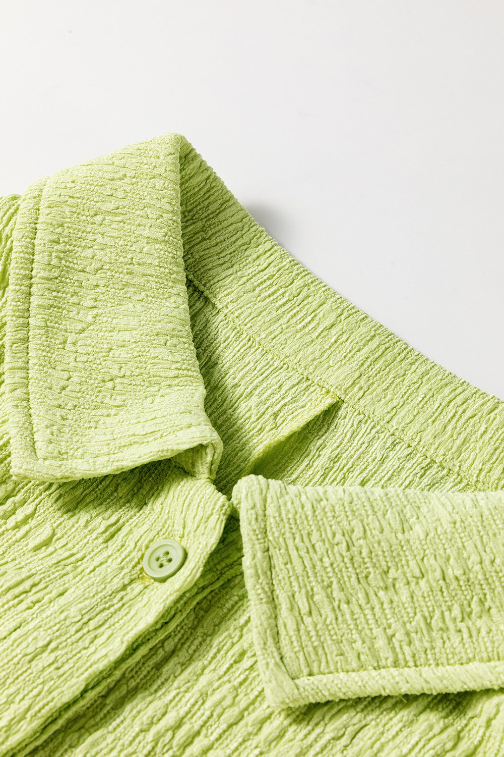 Lime textured collared romper with button detail and patch pocket.