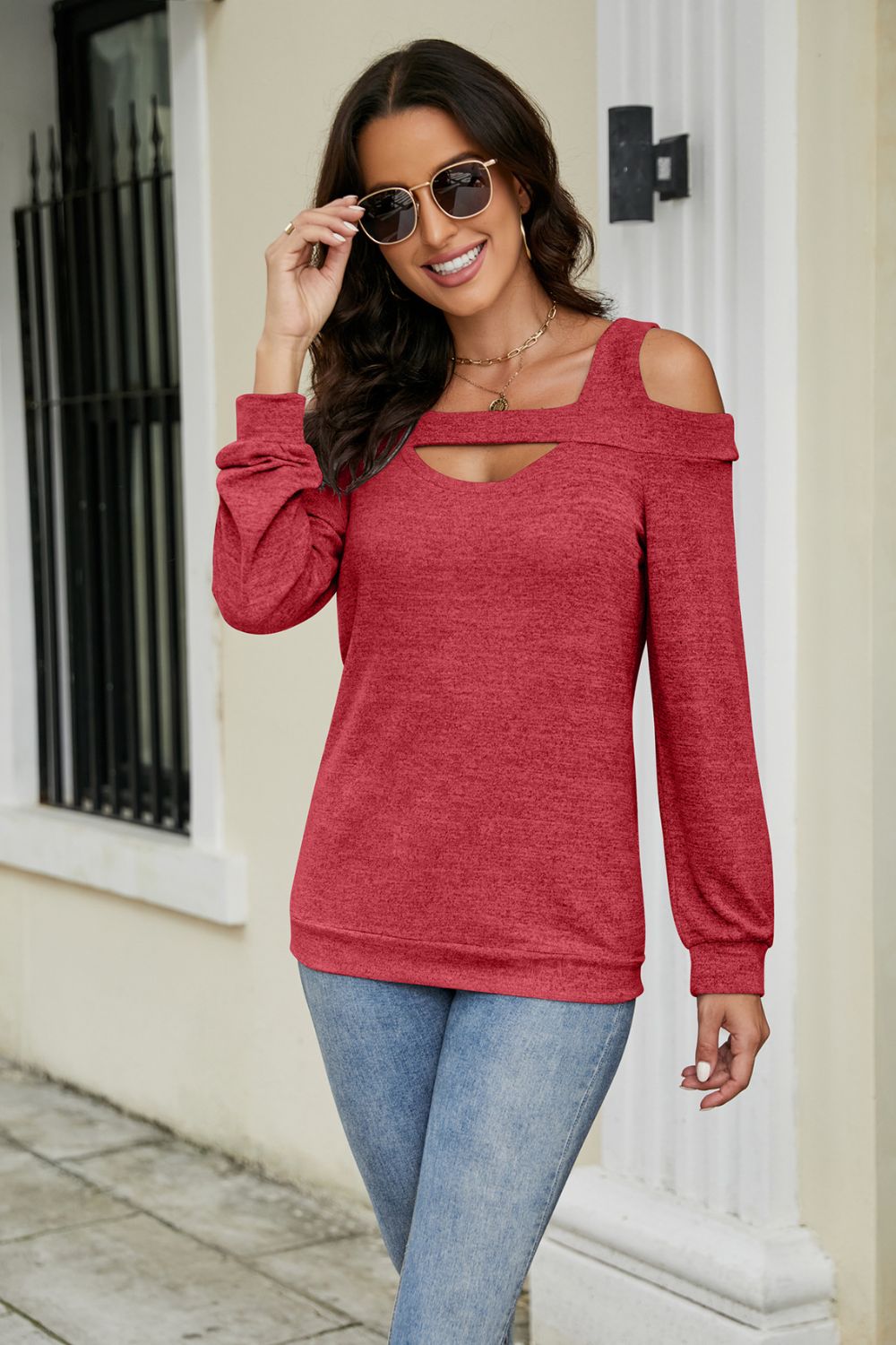 Red sweater with cutout shoulder detail and keyhole neckline.